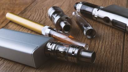  Various vaping devices on a wooden background