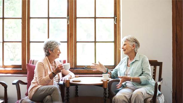 Two senior women talking and drinking tea