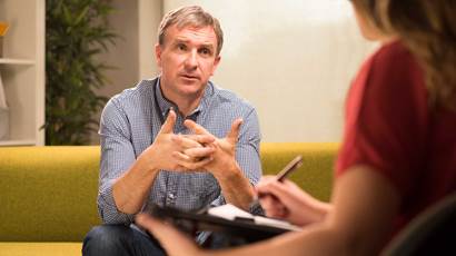 Man sitting on couch speaking to therapist