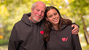 A father with his arm around his daughter, both wearing Heart & Stroke branded hoodies.